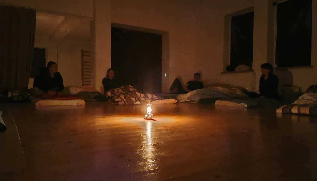 The Dark Retreat: participants resting on mattresses around a single lamp